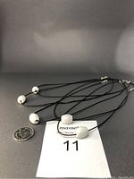 Lot of 5 white Burma jade pendants on black PU leather chains with silver clasps and fittings, shown next to a US quarter for size reference.