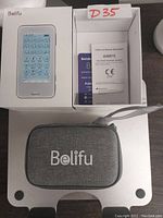 Belifu TENS and muscle stimulator device box with user manual inside, showing model AS8015 and certification marks.