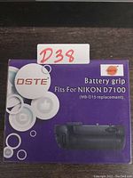Box front showing the DSTE branding, product name, compatibility with Nikon D7100, and image of the battery grip.