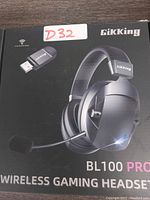 Front of the retail box showing the Gikking BL100 Pro Wireless Gaming Headset with USB connector included. Headset is depicted in black color with boom mic shown, and Gikking branding on headset and USB dongle.
