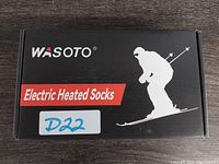 The front of the black box labeled WASOTO Electric Heated Socks with an illustration of a skier.