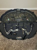 Overview of Martin model compound bow and 4 arrows in molded hard plastic carrying case.