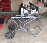 Full view of Ridgid miter saw mounted on stand with wheels