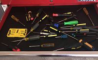 Drawer with multiple screwdrivers with black and yellow handles, including Stanley set