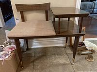 Full front view of vintage melamine phone table showing the upholstered seat, wooden chair back, melamine top and shelf, tapered legs with metal foot caps.