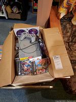 Cardboard box containing console, controller, two jewel case games and loose discs