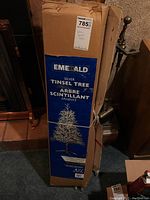 Photo of original packaging box showing brand, product name, and size (4.5 feet) with image of silver tinsel tree on stand.