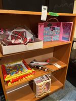 Wide shot of shelving with diverse toys including Barbie doll case, model airplane, educational peg board, and matching accessories.