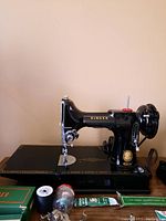 Overview of sewing machine on case with accessories and motor
