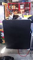 Upright folded black folding table in garage clutter environment