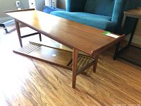 Full view of the complete coffee table showing main top surface and detached bottom shelf resting on floor.