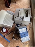 Overview photo showing monitor, keyboard, vintage CPU tower, Logitech keyboard, and surge protector on carpeted floor near window light.
