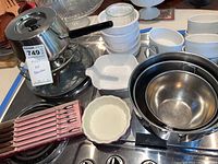 Photo showing stainless steel fondue pot, stacked white Pyrex mixing bowls, white ceramic baking dishes, and wooden-handled fondue forks in box.