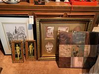 Six framed wall art pieces arranged on floor including classical prints, multi-picture holder, and abstract art
