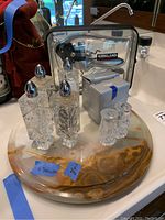 Full set of crystal salt and pepper shakers, Kirkland rabbit corkscrew opener and marble trivet arranged on marble surface.