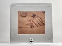 View of framed lithograph mounted on white board with photo corners and shrink wrap