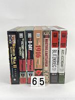 Photo showing the spines of seven large pop-up war books in slipcases with titles related to major 20th century conflicts.