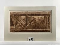 Front view of colour etching mounted on white acid-free board with visible photo corners and number 70 in front.