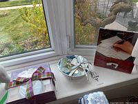 Photo of decorative bath set items including a floral bowl, tied with ribbons, and boxes visible