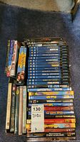 Photo showing lot of DVDs stacked with several IMAX titles visible, children's and movie DVDs also visible.