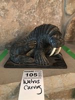 Front view showing the walrus face, white tusks, and detailed textured body on a rectangular base.