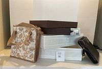 Stack of items including floral patterned cloth bag, brown trays, white drawer organizers, and black zippered case.