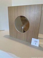 Front view of the wooden square cabinet with a centered round mirror inset on the door.