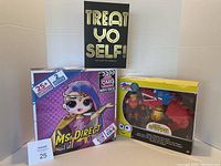 Photo showing all three items including the Ms Direct doll box, Minions story pack, and Treat Yo Self card game box.