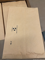 Close up photo of padded mailer envelopes inside the box, showing the size and cushioning noted as not bubble padding. Printed label includes "No 5" and recycling symbol.