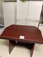 Image showing the foldable desktop lectern podium with reddish-brown wood grain finish from front angle.