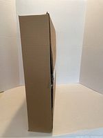 Side view of a single assembled cardboard box, showing thickness and structure of single wall.