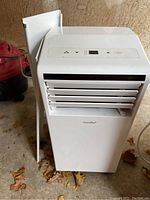 Front and side view of white Comfee portable air conditioner with adjustable front vents and control panel on top.