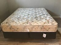 Front view of assembled queen bed frame with mattress and box springs