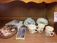 Photo of children's china tea set, including Bunnykins mugs, Wedgewood cups with saucers, children's bowls, Birks Regency silver plated cutlery in box, and Goldilocks collector plate with COA.