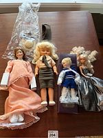 All four dolls arranged on table showing size and clothing details