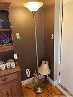 Photo showing both lamps: one tall floor lamp with frosted glass shade and one smaller ceramic table lamp with fabric shade