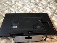 Rear view of the Philips 32-inch TV showing back panel with connection ports and power cable.