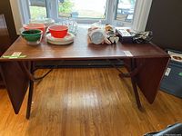 Full view of teak table with leaves down and tabletop items