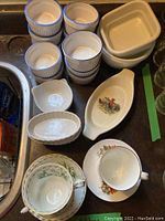 Overhead view of various ramekins, tea cups, saucers, bowls, and serving dishes on countertop