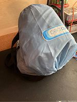 Blue Aero Bed inflatable air mattress in fabric carrying bag with black strap, showing Aero Bed logo.