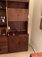 Full view of the Drexel wooden cabinet showing closed upper and lower cabinet doors and overall wood finish.