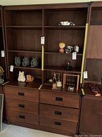 Full view of the Drexel wooden cabinet with shelves and various decorative items displayed on the shelves and drawers.