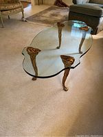 Overall view showing freeform glass top and all four gold-painted legs