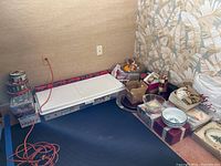 Wide shot of holiday tins, bowls, decorative items, and wrapping paper on the floor