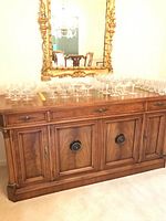 Front view of J. L. Mentz Mid-Century Modern buffet with glassware on top, showing wood grain and door design.