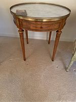 Overall view of round table showing marble top and wood base