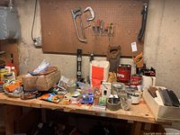 Workbench with assorted tools, tapes, polishing supplies, small hardware and packaging boxes