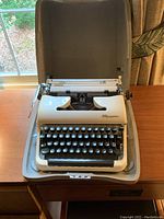 Front view of typewriter placed in open hard shell case