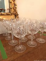 Group of 12 crystal red wine glasses arranged on wooden surface