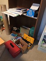 Wide view of lots including toolboxes, craft sticks, papers, and boxes